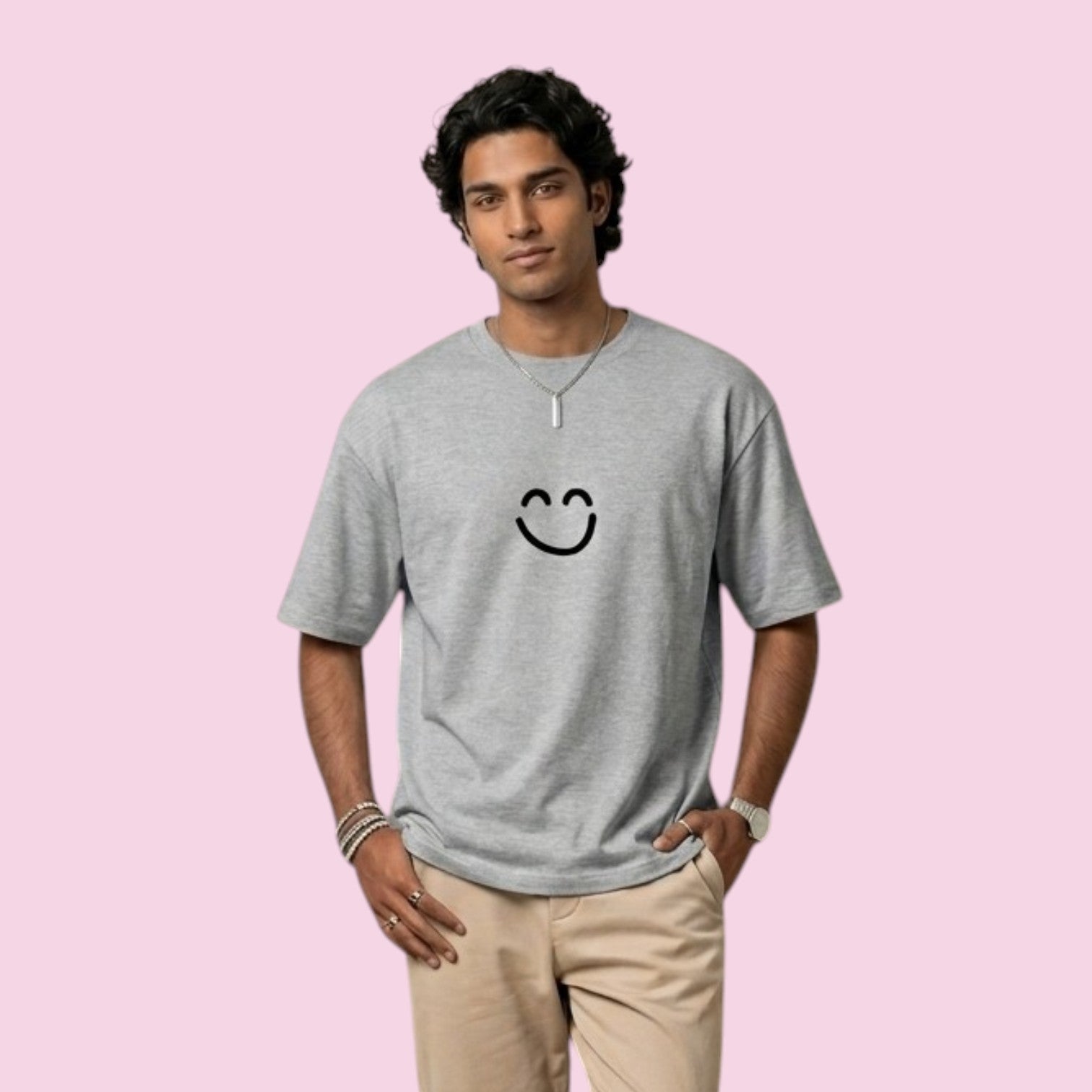 Man modeling a light grey oversized streetwear t-shirt featuring the iconic black smiley face design inspired by the Dan Da Dan anime series.