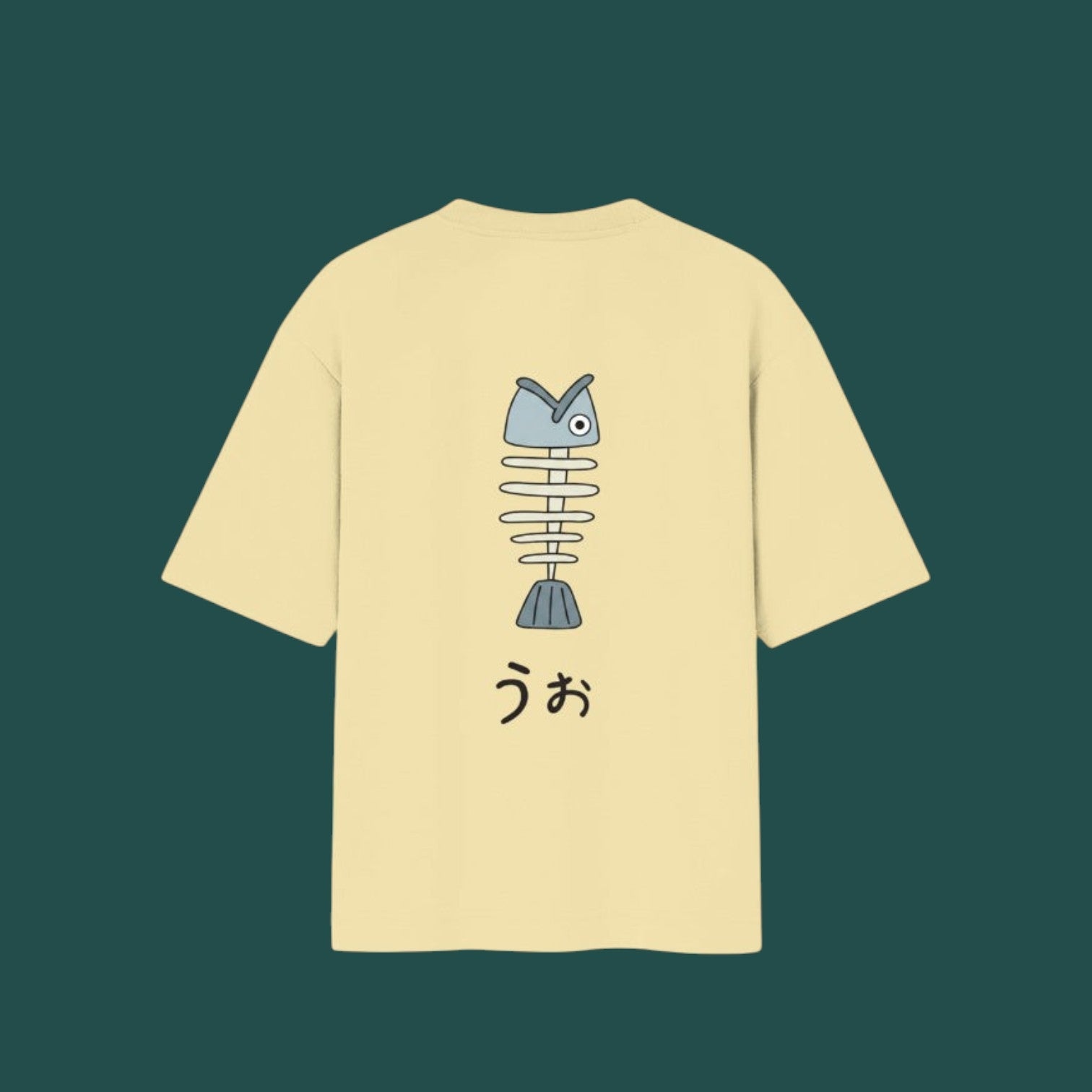 Back view of a pale yellow t-shirt inspired by the Dandadan anime, featuring a cartoonish fish skeleton graphic and Japanese text underneath.